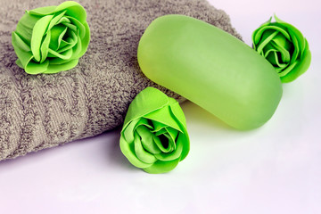 Fragrant lime soap and a bath towel lie on a light surface