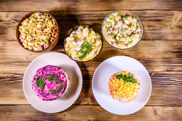 Set of festive mayonnaise salads on wooden table. Top view