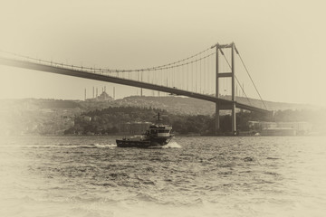 Bosphorus Bridge and a cargo ship, retro style photo, Istanbul