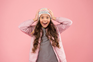 Full of happiness. warm clothes for cold season. knitted accessory. small girl winter hat. kid fashion. trendy girl look like hipster. surprised child pink background. autumn style. happy childhood