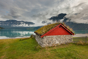 Beautiful lonely house on a green meadow near the lake