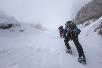 Fototapeta na wymiar People climbers go up the on snow mountain
