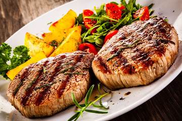 Grilled steak with baked potatoes and vegetables