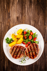 Grilled steak with baked potatoes and vegetables