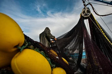 Foto op Canvas Fishermen in protective suits on deck Fishing vessel. © sezer66