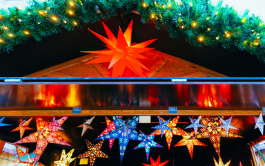 Paper star light decoration at Christmas Market in Winter Berlin, Germany. Advent Fair and Stalls with Crafts Items on the Bazaar. In Europe. German street Xmas and holiday in European city or town.