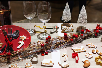 Christmas table setting with ginger cookies and holly berries decorations. Christmas holiday decorations.
