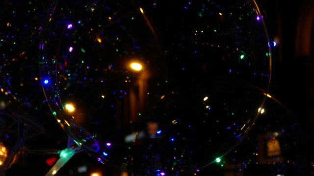 Transparent balloon with colorful LED lights against dark background