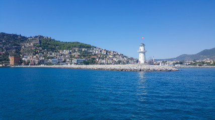 Fototapeta na wymiar Lighthouse in the port of Alanya. Sea view of the lighthouse in Alanya Turkey.