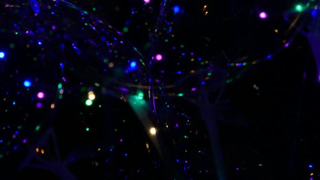 Transparent balloon with colorful LED lights against dark background