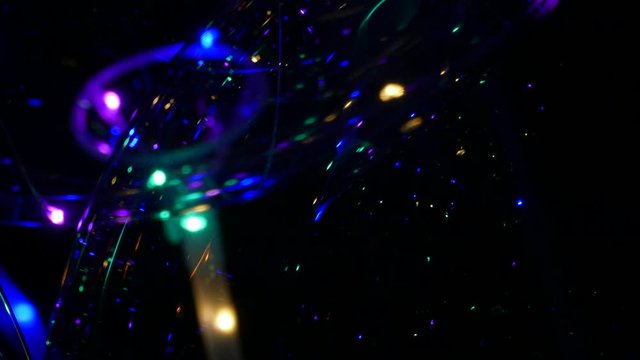 Transparent balloon with colorful LED lights against dark background