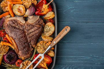 tender and juicy steak on the bone grilled next to baked and grilled vegetables, the concept of tasty and healthy nutrition
