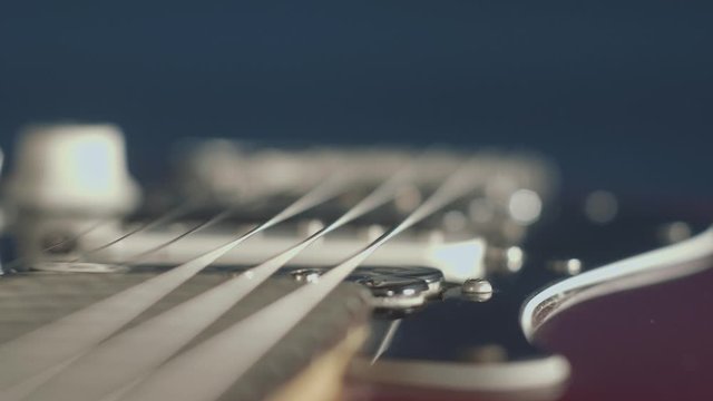 Extreme close up dolly shot of a red electric guitar