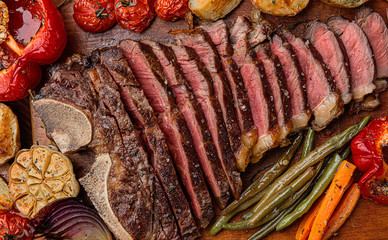 marbled beef steak on the bone cooked to a state of medium rare grill. next to the steak, grilled...