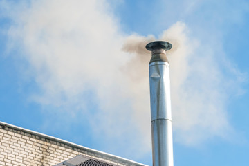 Smoke from the chimney against the blue sky. Pipe with smoke. Emissions of pipes into the atmosphere. Harmful emissions into the atmosphere. concept of ecology