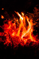 Heat from bright flame of dying bonfire. Close-up.