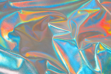 Iridescent fabric background. Shiny mother of pearl fabric, bright multi-colored fabric