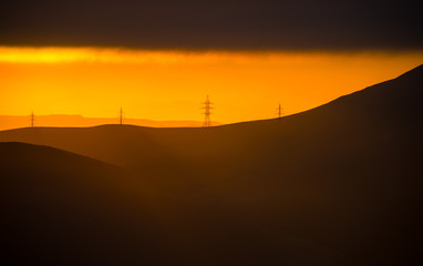 Cloudy weather. Zoom shot. Orange sunset view at mountains in Azerbaijan
