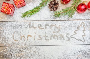 concept of Christmas or New year background. Text made of flour and festive Christmas decoration on the table.