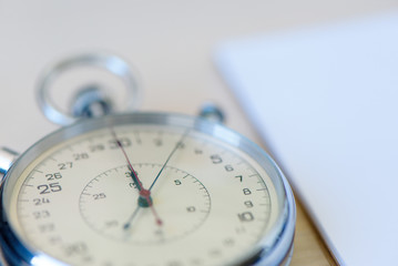 Notepad And Stopwatch close up biege desk table background