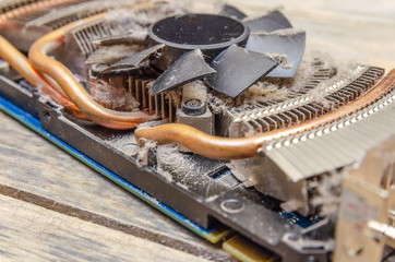 Dust on CPU cooler video card computer close up on wooden table