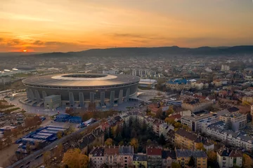 Wandaufkleber Erstaunliches Stadtbild über Budapest mit Ferenc Puskas Arena. Atemberaubender Sonnenuntergang im Hintergrund. © GezaKurkaPhotos