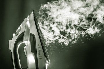 superheated steam with a powerful blow flies out of the hot sole of the iron