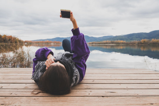 young girl lying making a selfie in a lake