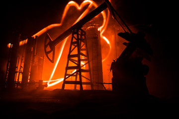 Artwork decoration. Oil pump and oil rig energy industrial machines for petroleum at night with fog and backlight. Oil refining factory. Energy industrial concept. Selective focus