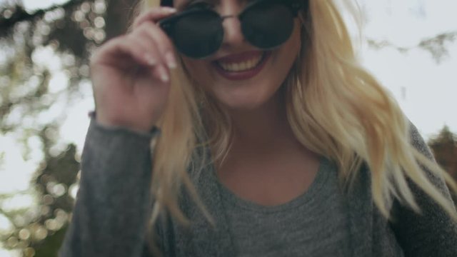 Blonde Woman Plus Size Wear Sunglasses Outside. Young Caucasian Girl Smile Lean Forward Nature Background. Female Adult Laugh Happy Moments Casual Clothes Look Leisure Activity Slow Motion 4K