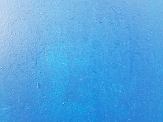 On a concrete blue wall there were traces of smudges of paint.