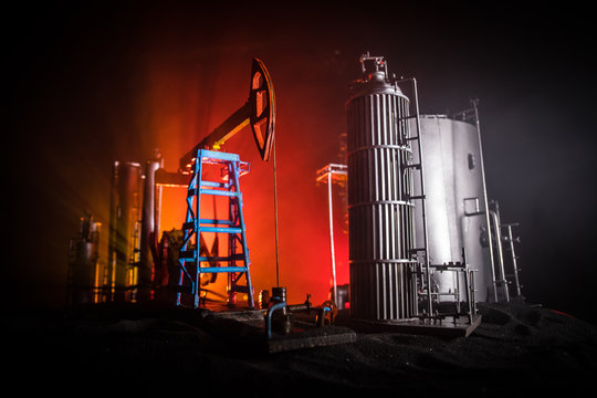 Artwork decoration. Oil pump and oil rig energy industrial machines for petroleum at night with fog and backlight. Oil refining factory. Energy industrial concept. Selective focus