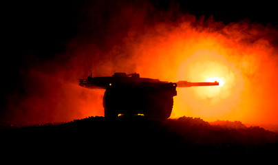 War Concept. Armored vehicle silhouette fighting scene on war foggy sky background at night....