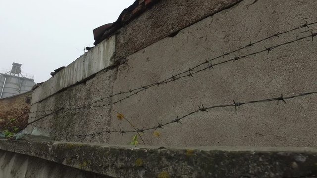 Barbed wire, fragments of broken bottles along upper edge of fence in USSR, security system