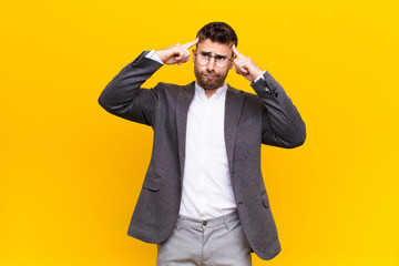 young handosme man looking concentrated and thinking hard on an idea, imagining a solution to a...