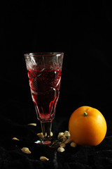 Crystal glass with red wine and one citrus nearby.