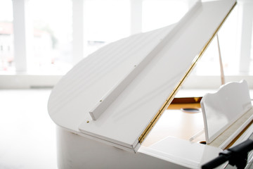 white Grand piano in a beautiful light interior