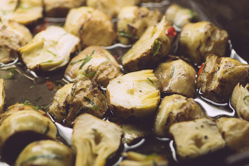 Pickled artichokes in oil and herbs. Classic italian appetizer for wine in italian cuisine. Vegetarian snack
