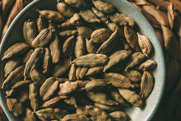 Heap of cardamom seeds in a bowl, close up view. 