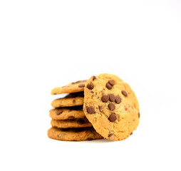 Some sweet cookies with chocolate laying on top of each other and one is near on isolated white background.