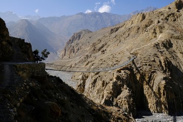 Dramatic view of the hanging bridge over the river in the Kali Gandaki Valley. Nepal, Mustang, Himalaya, trekking around Annapurna