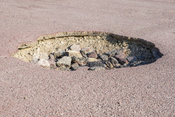 cracked hole in the asphalt road