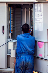 Electrician worker checking transformation box on the street