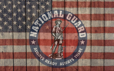 vintage american flag and national guard insignia painted on an old barn wall