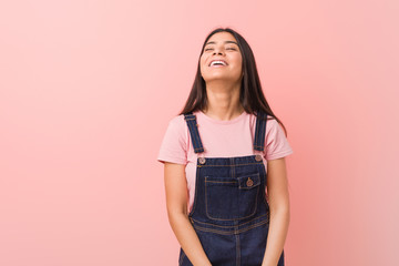 Young pretty arab woman wearing a jeans dungaree relaxed and happy laughing, neck stretched showing teeth.