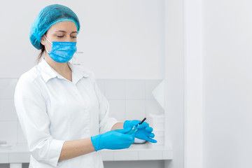 gloved nurse removes sterile needle from packaging