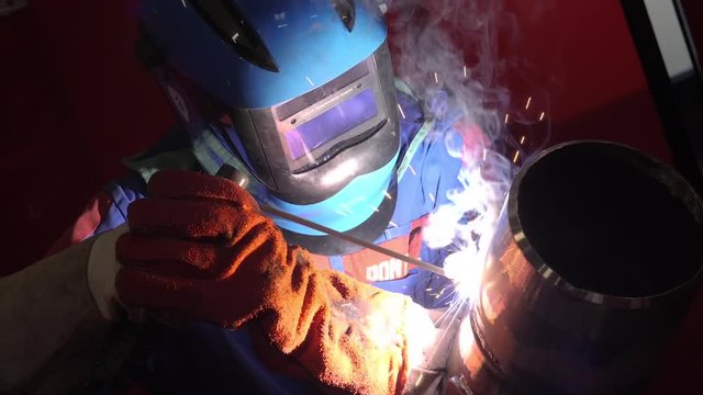Man welding a pipe in slow motion