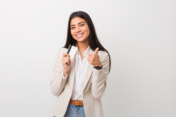 Young arab woman holding a credit card smiling and raising thumb up