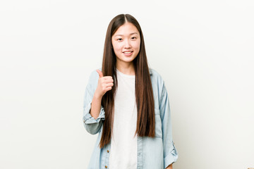 Fototapeta premium Young asian woman smiling and raising thumb up