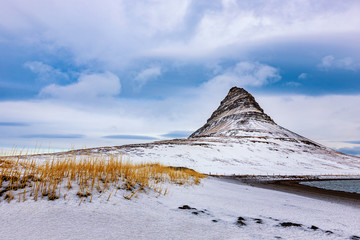 Famous mountain with waterfalls in Iceland,  kirkjufell, winter in Iceland, ice and snow, reflections, yellow grass, nature, icelandic famous landscape